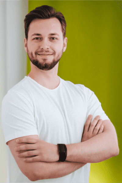 Philipp Starzacher Backend Developer Synaptos lächelt warm und trägt dabei ein weißes Hemd.