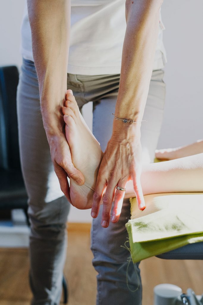 Podologin behandelt Patientin an Fußsohle