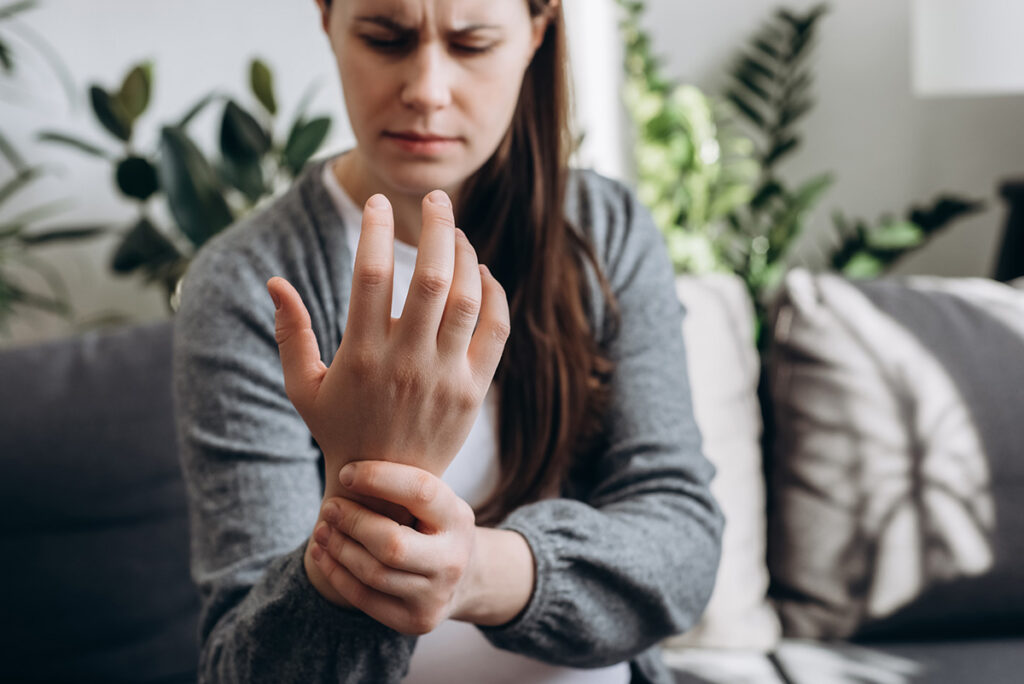 Junge Frau mit Arthritis im Handgelenk